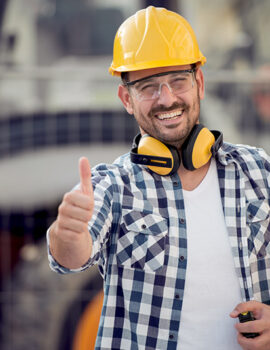 Portrait of a cheerful male architect wearing hardhat and showing thumbs up.